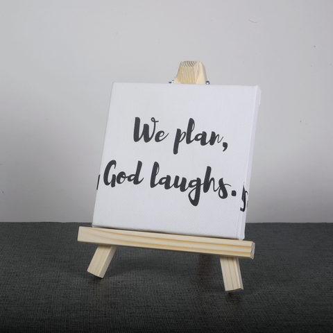 Easel Stand with Mini Canvas Motivational Quote “We plan god laughs” for Office/Desk Decor/Home Decoration/Gift Purpose/Table Decorative Showpiece.